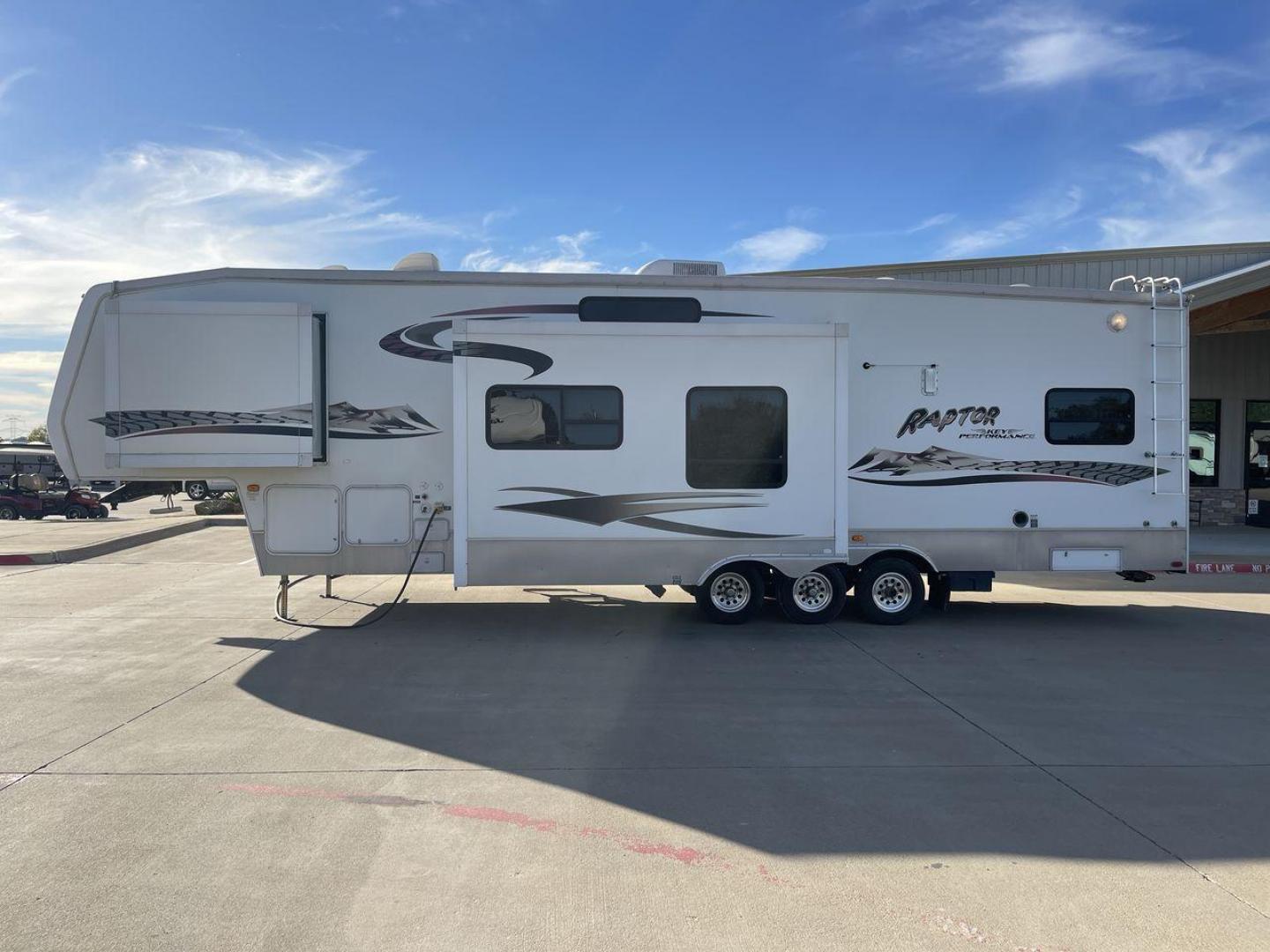 2006 KEYSTONE RAPTOR (4YDF361376M) , Length: 37.58 ft | Dry Weight: 11,615 lbs | Slides: 2 transmission, located at 4319 N Main Street, Cleburne, TX, 76033, (817) 221-0660, 32.435829, -97.384178 - The 2016 Keystone Raptor RP3612 is a fifth-wheel toy hauler with a bold and functional exterior. It features a white body with stylish decals that include swooping lines and mountain graphics, giving it a sporty and adventurous look. The RV has three axles, offering stability and support for its lar - Photo#23