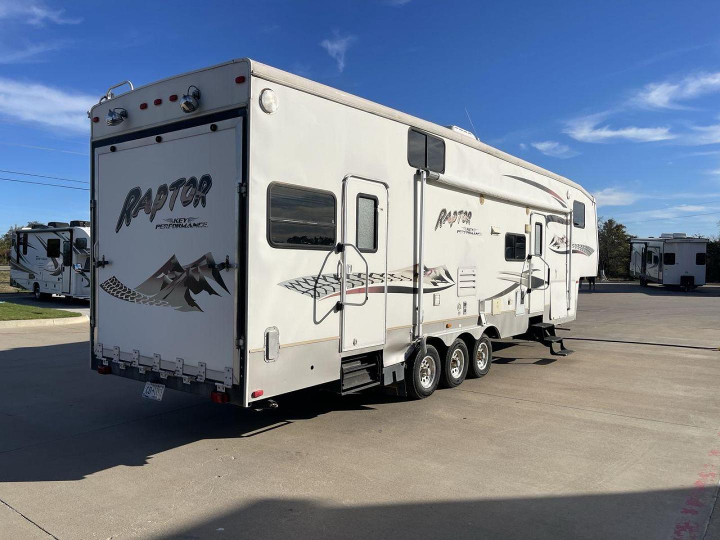 2006 KEYSTONE RAPTOR (4YDF361376M) , Length: 37.58 ft | Dry Weight: 11,615 lbs | Slides: 2 transmission, located at 4319 N Main Street, Cleburne, TX, 76033, (817) 221-0660, 32.435829, -97.384178 - The 2016 Keystone Raptor RP3612 is a fifth-wheel toy hauler with a bold and functional exterior. It features a white body with stylish decals that include swooping lines and mountain graphics, giving it a sporty and adventurous look. The RV has three axles, offering stability and support for its lar - Photo#24