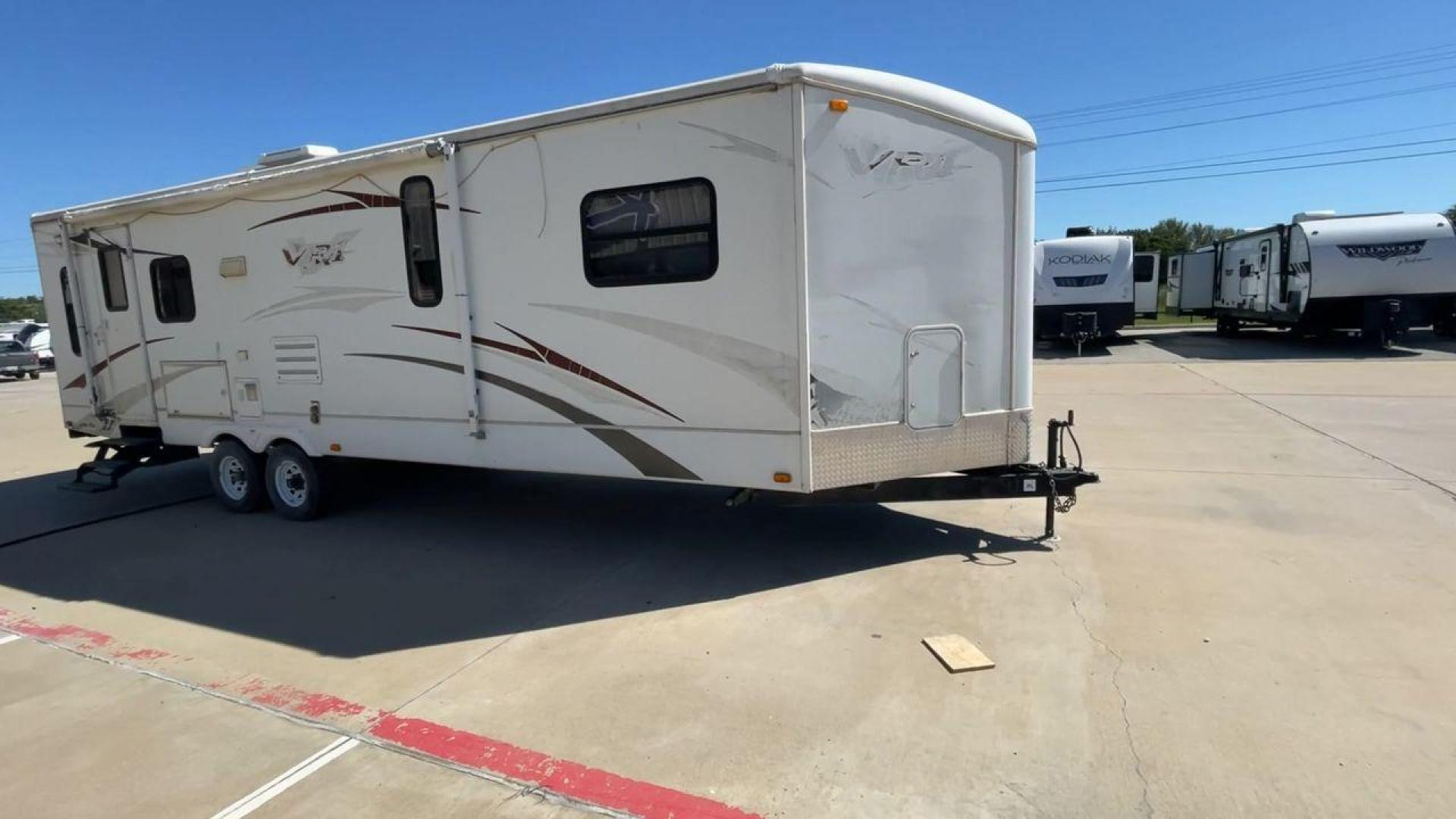 2008 WHITE VR-1 299RLS (4YDT299268V) , Length: 33 ft. | Dry Weight: 6,810 lbs. | Slides: 1 transmission, located at 4319 N Main Street, Cleburne, TX, 76033, (817) 221-0660, 32.435829, -97.384178 - The 2008 VR-1 299RLS is a dual-axle steel wheel setup measuring 33 ft. long and 11.17 ft. tall. It has a dry weight of 6,810 lbs. and a payload capacity of 2,805 lbs. It also has a hitch weight of 815 lbs. It includes one slide and one power awning. This travel trailer features a rear living floorpl - Photo#3