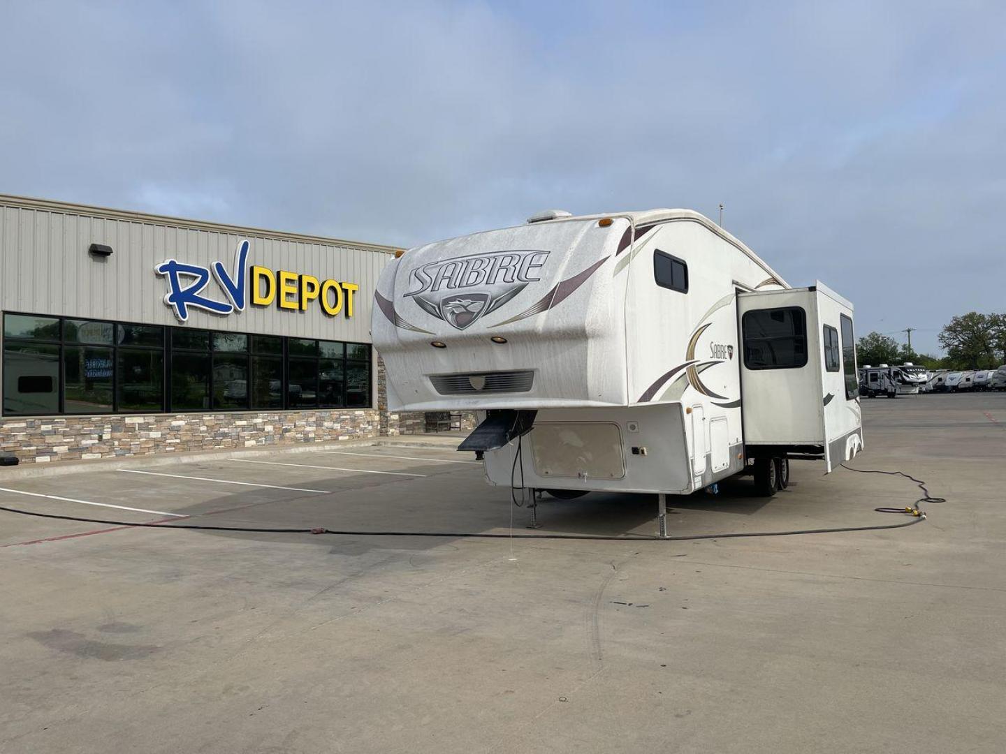 2010 WHITE FOREST RIVER SABRE 32QBDS - (4X4FSRH28A3) , Length: 35 ft. | Dry Weight: 9,235 lbs. | Gross Weight: 11,682 lbs. | Slides: 2 transmission, located at 4319 N Main Street, Cleburne, TX, 76033, (817) 221-0660, 32.435829, -97.384178 - This 2010 Forest River Sabre 32QBDS has a very family-friendly floor plan. It measures 35 ft in length and has a dry weight of 9,235 lbs. The gross weight is 11,682 lbs, and it has two slides. The door leads you to the central living and kitchen area. The living area comes with an entertainment cent - Photo#0