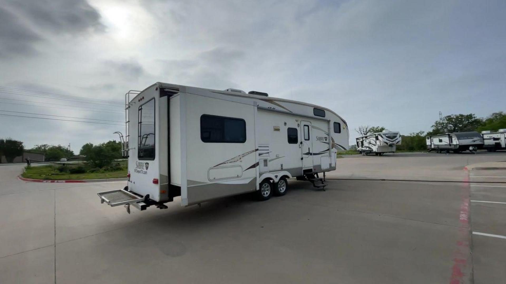 2010 WHITE FOREST RIVER SABRE 32QBDS - (4X4FSRH28A3) , Length: 35 ft. | Dry Weight: 9,235 lbs. | Gross Weight: 11,682 lbs. | Slides: 2 transmission, located at 4319 N Main Street, Cleburne, TX, 76033, (817) 221-0660, 32.435829, -97.384178 - This 2010 Forest River Sabre 32QBDS has a very family-friendly floor plan. It measures 35 ft in length and has a dry weight of 9,235 lbs. The gross weight is 11,682 lbs, and it has two slides. The door leads you to the central living and kitchen area. The living area comes with an entertainment cent - Photo#1