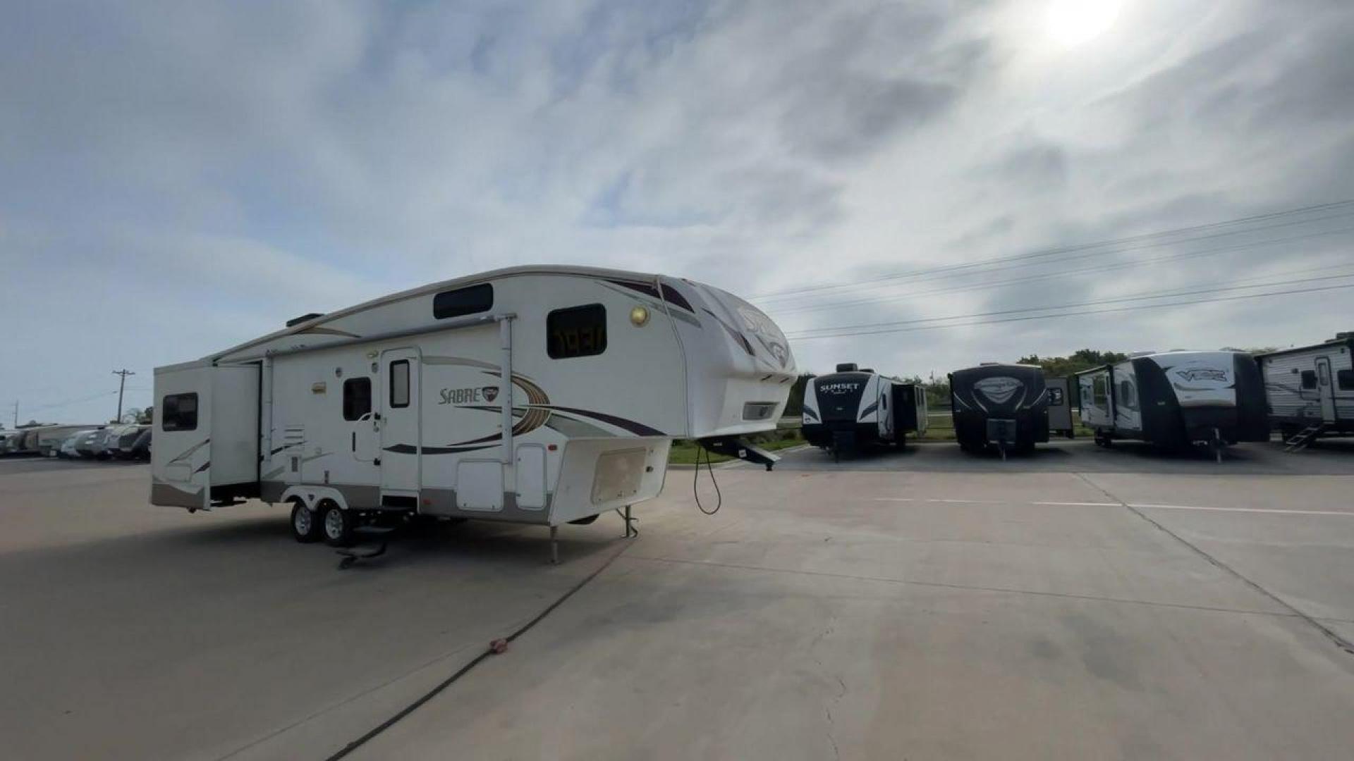 2010 WHITE FOREST RIVER SABRE 32QBDS - (4X4FSRH28A3) , Length: 35 ft. | Dry Weight: 9,235 lbs. | Gross Weight: 11,682 lbs. | Slides: 2 transmission, located at 4319 N Main Street, Cleburne, TX, 76033, (817) 221-0660, 32.435829, -97.384178 - This 2010 Forest River Sabre 32QBDS has a very family-friendly floor plan. It measures 35 ft in length and has a dry weight of 9,235 lbs. The gross weight is 11,682 lbs, and it has two slides. The door leads you to the central living and kitchen area. The living area comes with an entertainment cent - Photo#3