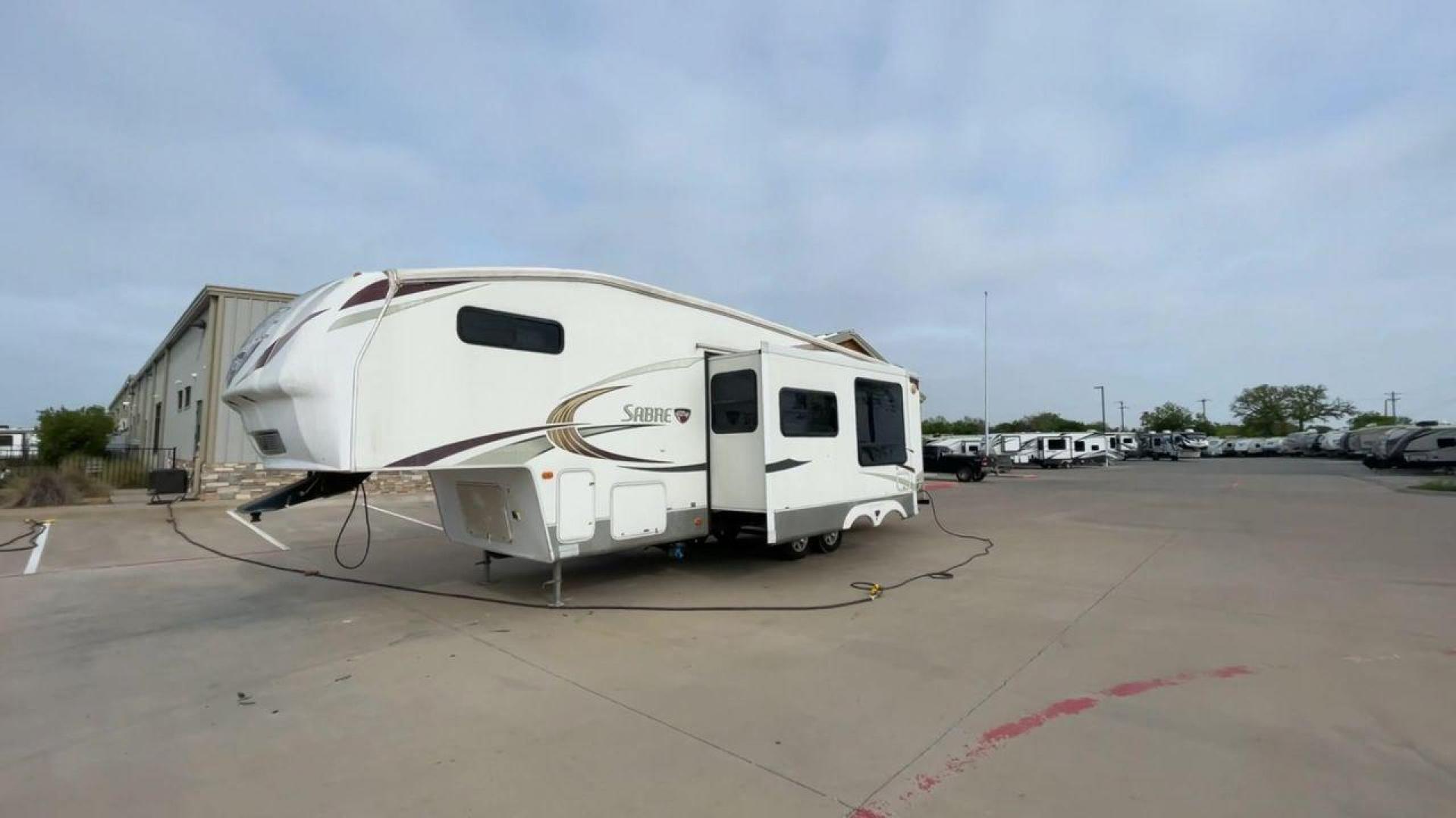 2010 WHITE FOREST RIVER SABRE 32QBDS - (4X4FSRH28A3) , Length: 35 ft. | Dry Weight: 9,235 lbs. | Gross Weight: 11,682 lbs. | Slides: 2 transmission, located at 4319 N Main Street, Cleburne, TX, 76033, (817) 221-0660, 32.435829, -97.384178 - This 2010 Forest River Sabre 32QBDS has a very family-friendly floor plan. It measures 35 ft in length and has a dry weight of 9,235 lbs. The gross weight is 11,682 lbs, and it has two slides. The door leads you to the central living and kitchen area. The living area comes with an entertainment cent - Photo#5