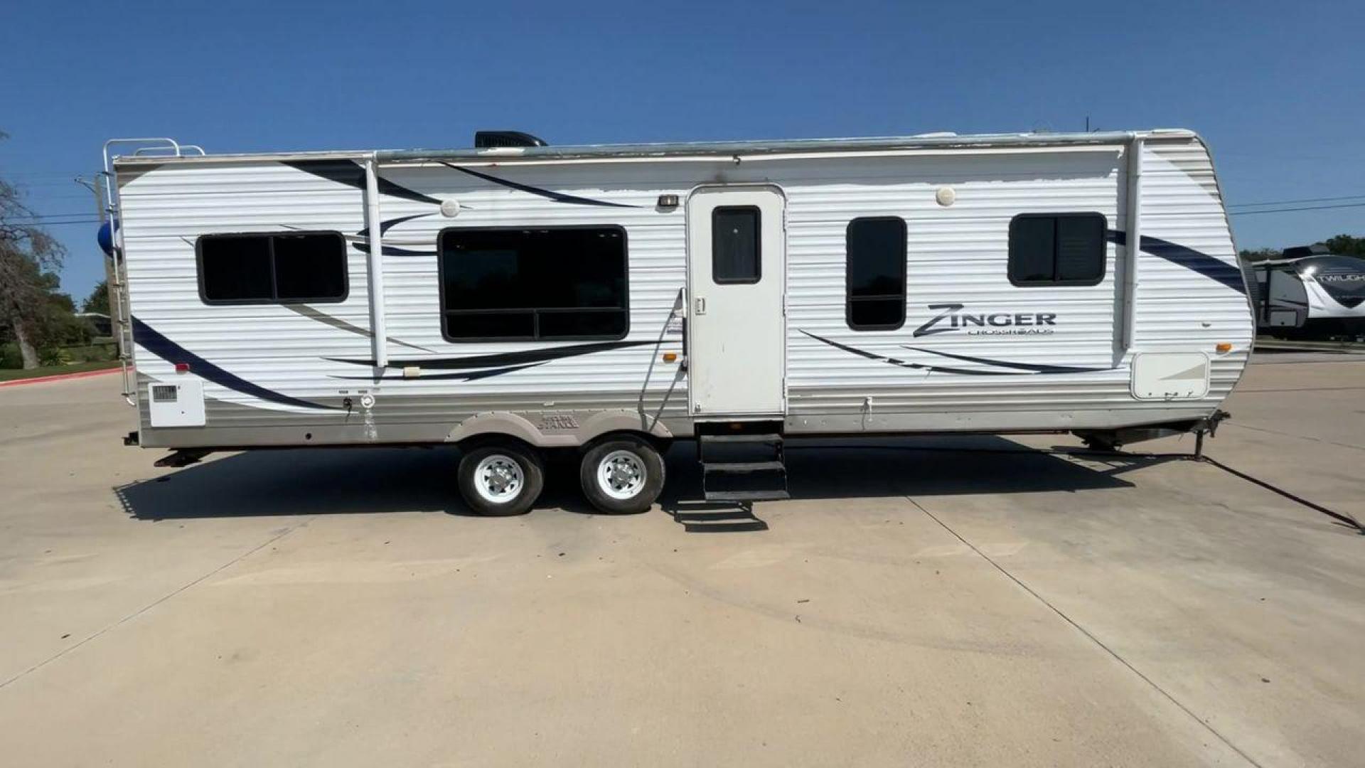 2012 CROSSROAD ZINGER 300RK - (4V0TC3024CA) , Length: 33.67 ft. | Dry Weight: 6,917 lbs. | Slides: 1 transmission, located at 4319 N Main Street, Cleburne, TX, 76033, (817) 221-0660, 32.435829, -97.384178 - The 2012 Crossroads Zinger 300RK is a well-designed travel trailer. At 33.67 ft long, this trailer offers a rear kitchen layout, slide-out living space, and a variety of amenities designed to make your home on the road as comfortable as possible. It showcases a sleek exterior with white aluminum sid - Photo#2