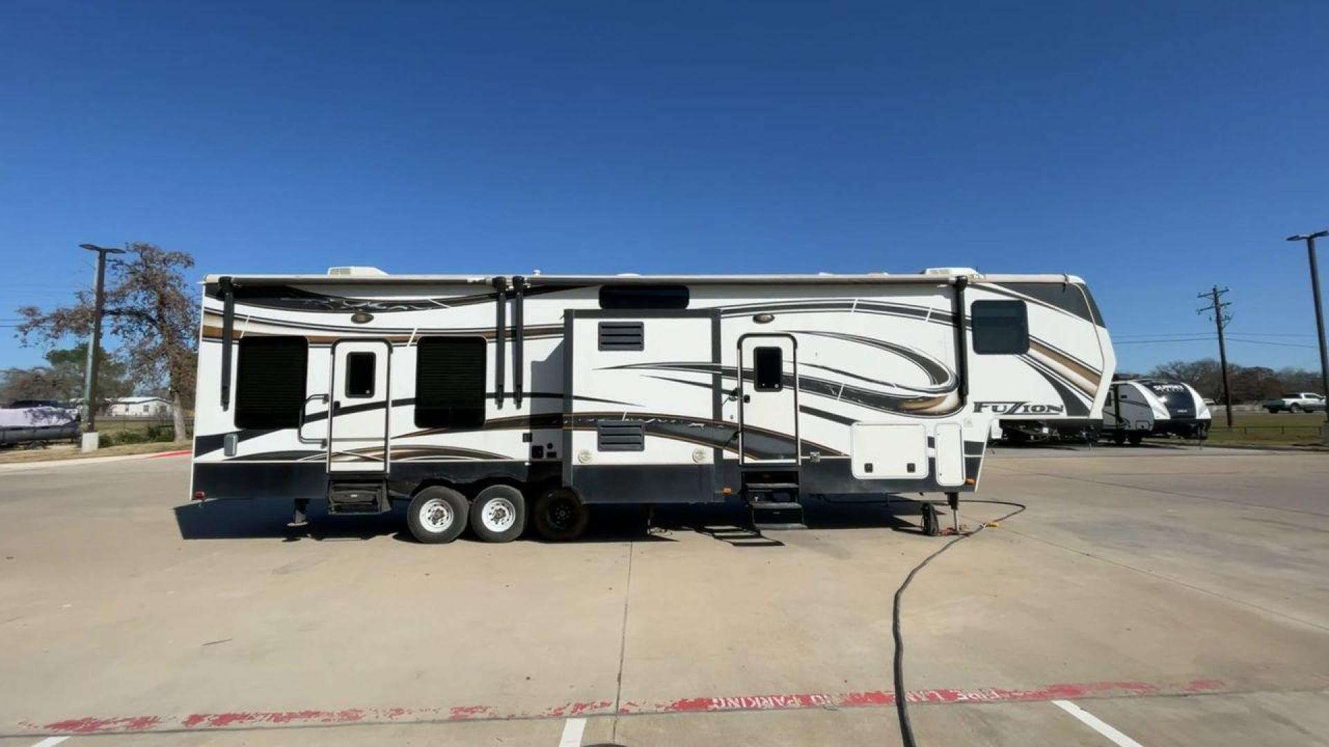 2013 WHITE KEYSTONE FUZION FZ399 - (4YDF39923DF) , Length: 41 ft. | Dry Weight: 13,880 lbs. | Gross Weight: 18,000 lbs. | Slides: 3 transmission, located at 4319 N Main Street, Cleburne, TX, 76033, (817) 221-0660, 32.435829, -97.384178 - The 2013 Keystone Fuzion FZ399 toy hauler measures 41 ft in length, 8.5 ft in width, and 13.25 ft in height. It has a dry weight of 13,880 lbs with a payload capacity of 4,120 lbs. The GVWR is 18,000 lbs and has a hitch weight of 3,560 lbs. This has a triple axle and triple slide with one 20 ft powe - Photo#2