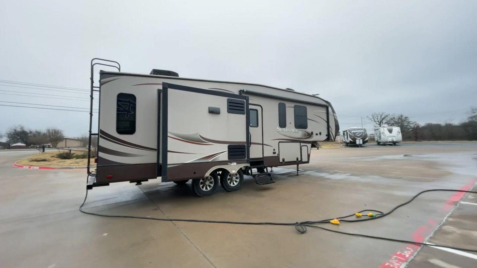 2014 TAN SUNDANCE 2880RLT (5SFSG3320EE) , Length: 32.2 ft. | Dry Weight: 9,750 lbs. | Gross Weight: 13,800 lbs. | Slides: 3 transmission, located at 4319 N Main Street, Cleburne, TX, 76033, (817) 221-0660, 32.435829, -97.384178 - This 2014 Sundance Fifth Wheel is just over 32 feet long and 8 feet wide. It has a GVWR of 13,800 lbs and a hitch weight of 2,220 lbs. The exterior of this fifth wheel is a stylish grey with brown, white, and beige decals. This model also has three slides and a 16-foot power-retractable awning. The - Photo#1