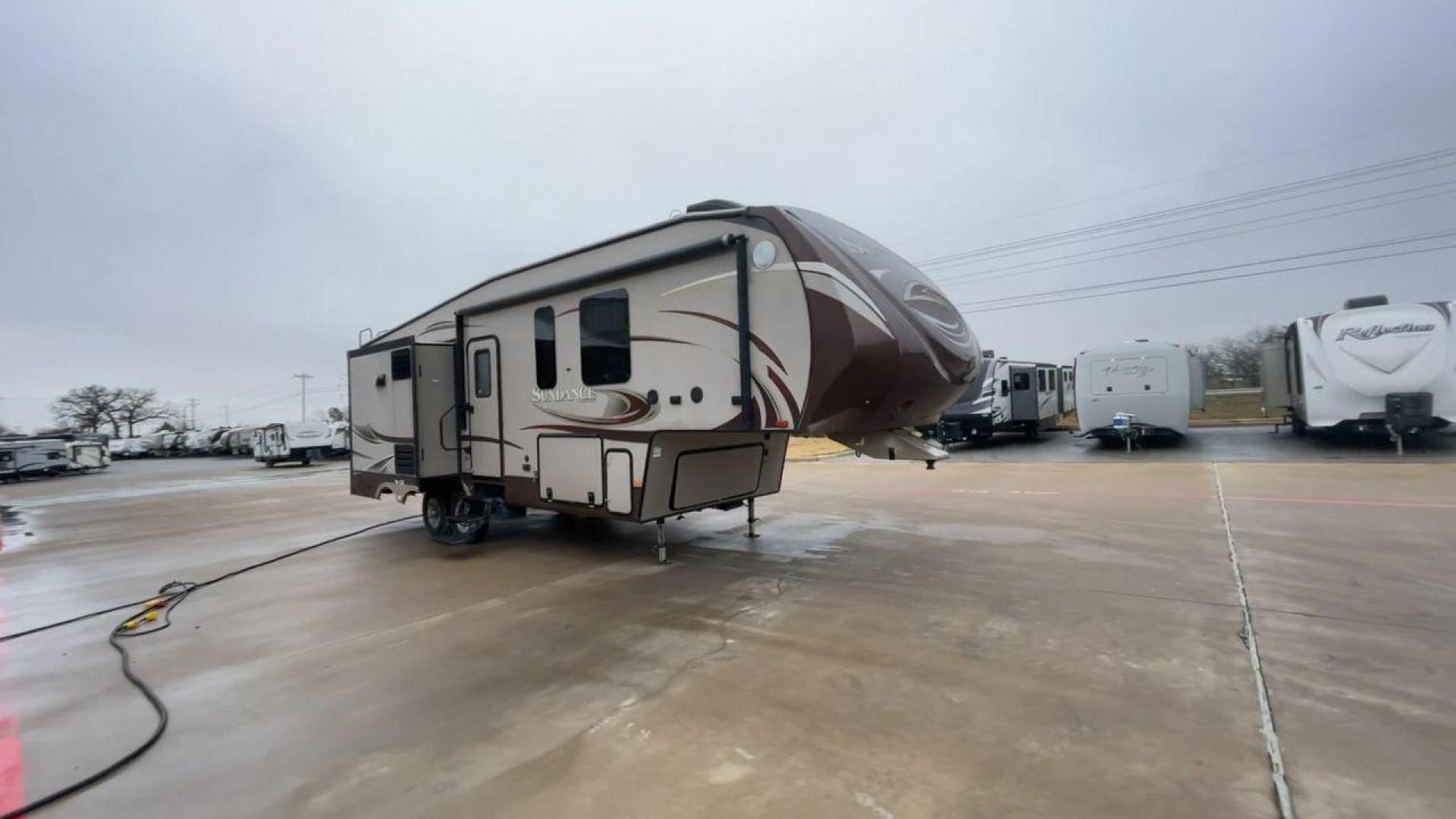 2014 TAN SUNDANCE 2880RLT (5SFSG3320EE) , Length: 32.2 ft. | Dry Weight: 9,750 lbs. | Gross Weight: 13,800 lbs. | Slides: 3 transmission, located at 4319 N Main Street, Cleburne, TX, 76033, (817) 221-0660, 32.435829, -97.384178 - This 2014 Sundance Fifth Wheel is just over 32 feet long and 8 feet wide. It has a GVWR of 13,800 lbs and a hitch weight of 2,220 lbs. The exterior of this fifth wheel is a stylish grey with brown, white, and beige decals. This model also has three slides and a 16-foot power-retractable awning. The - Photo#3