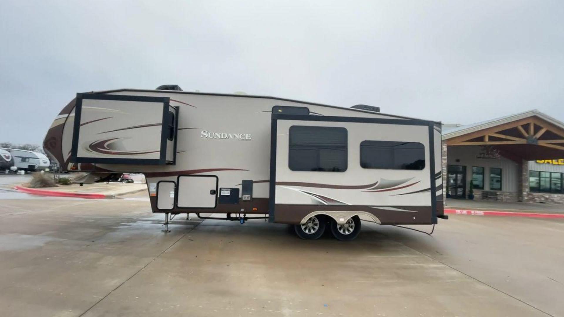 2014 TAN SUNDANCE 2880RLT (5SFSG3320EE) , Length: 32.2 ft. | Dry Weight: 9,750 lbs. | Gross Weight: 13,800 lbs. | Slides: 3 transmission, located at 4319 N Main Street, Cleburne, TX, 76033, (817) 221-0660, 32.435829, -97.384178 - This 2014 Sundance Fifth Wheel is just over 32 feet long and 8 feet wide. It has a GVWR of 13,800 lbs and a hitch weight of 2,220 lbs. The exterior of this fifth wheel is a stylish grey with brown, white, and beige decals. This model also has three slides and a 16-foot power-retractable awning. The - Photo#6