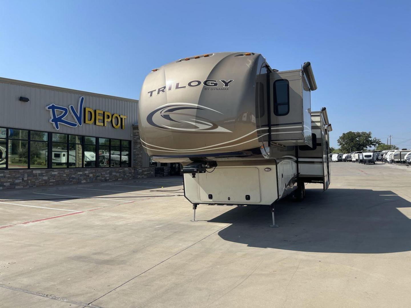 2015 TAN DYNAMAX TRILOGY 37BH - (5ZT3TL2B8FC) , Length: 42 ft. | Dry Weight: 15,638 lbs. | Gross Weight: 18,550 lbs. | Slides: 5 transmission, located at 4319 N Main Street, Cleburne, TX, 76033, (817) 221-0660, 32.435829, -97.384178 - This 2015 Trilogy Dynamax 37BH fifth wheel has 42.9 ft in length, 8.4 ft in width, and 13.2 ft in height. It has a dry weight of 15,638 lbs with a GVWR of 18,550 lbs and a hitch weight of 2,550 lbs. The exterior features a front storage capacity with a generator prep. It has extra-large pass-through - Photo#0