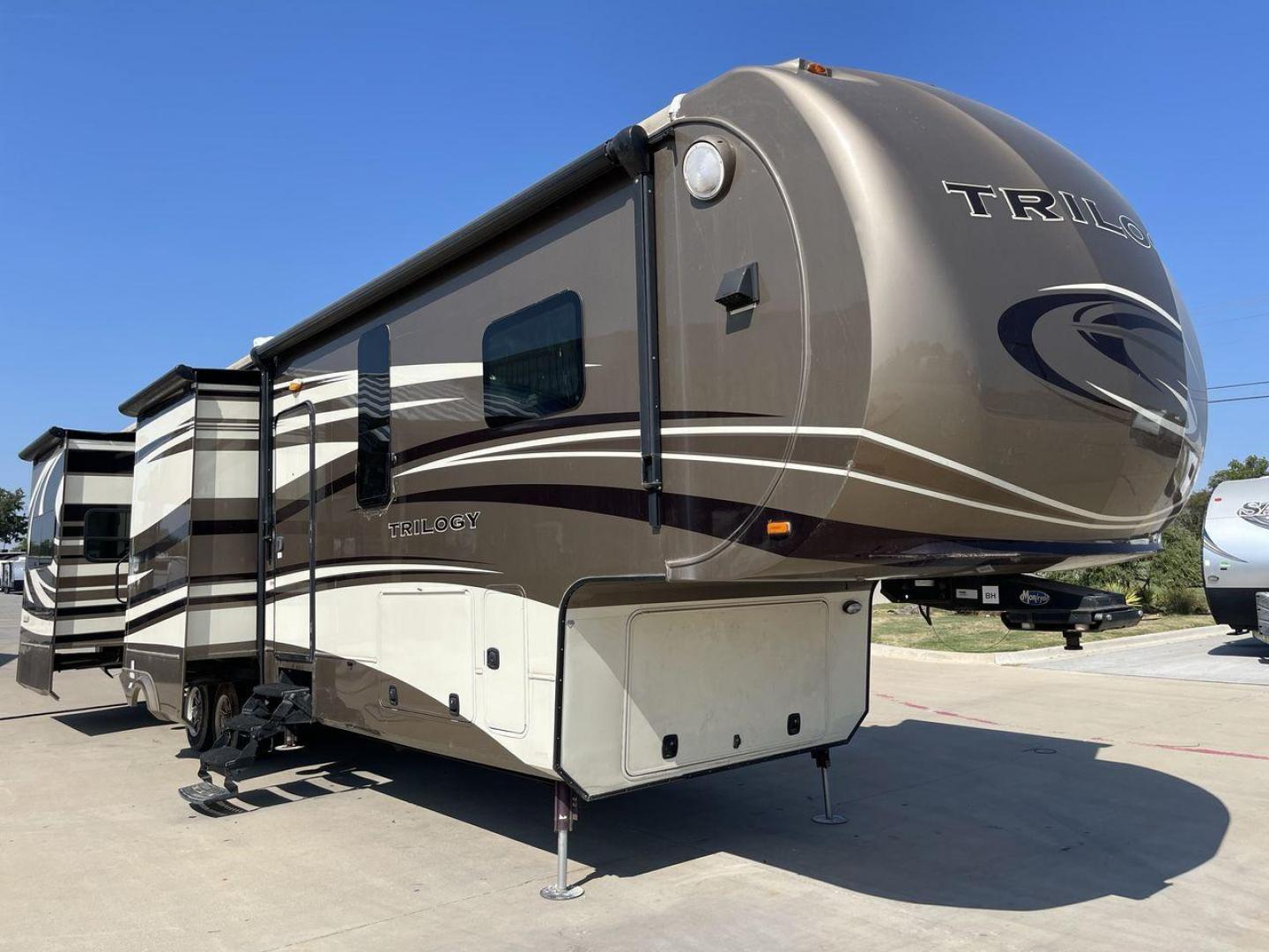 2015 TAN DYNAMAX TRILOGY 37BH - (5ZT3TL2B8FC) , Length: 42 ft. | Dry Weight: 15,638 lbs. | Gross Weight: 18,550 lbs. | Slides: 5 transmission, located at 4319 N Main Street, Cleburne, TX, 76033, (817) 221-0660, 32.435829, -97.384178 - This 2015 Trilogy Dynamax 37BH fifth wheel has 42.9 ft in length, 8.4 ft in width, and 13.2 ft in height. It has a dry weight of 15,638 lbs with a GVWR of 18,550 lbs and a hitch weight of 2,550 lbs. The exterior features a front storage capacity with a generator prep. It has extra-large pass-through - Photo#22