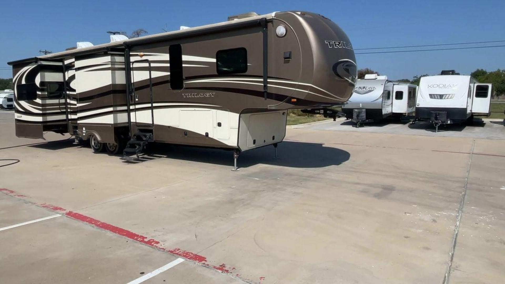 2015 TAN DYNAMAX TRILOGY 37BH - (5ZT3TL2B8FC) , Length: 42 ft. | Dry Weight: 15,638 lbs. | Gross Weight: 18,550 lbs. | Slides: 5 transmission, located at 4319 N Main Street, Cleburne, TX, 76033, (817) 221-0660, 32.435829, -97.384178 - This 2015 Trilogy Dynamax 37BH fifth wheel has 42.9 ft in length, 8.4 ft in width, and 13.2 ft in height. It has a dry weight of 15,638 lbs with a GVWR of 18,550 lbs and a hitch weight of 2,550 lbs. The exterior features a front storage capacity with a generator prep. It has extra-large pass-through - Photo#3