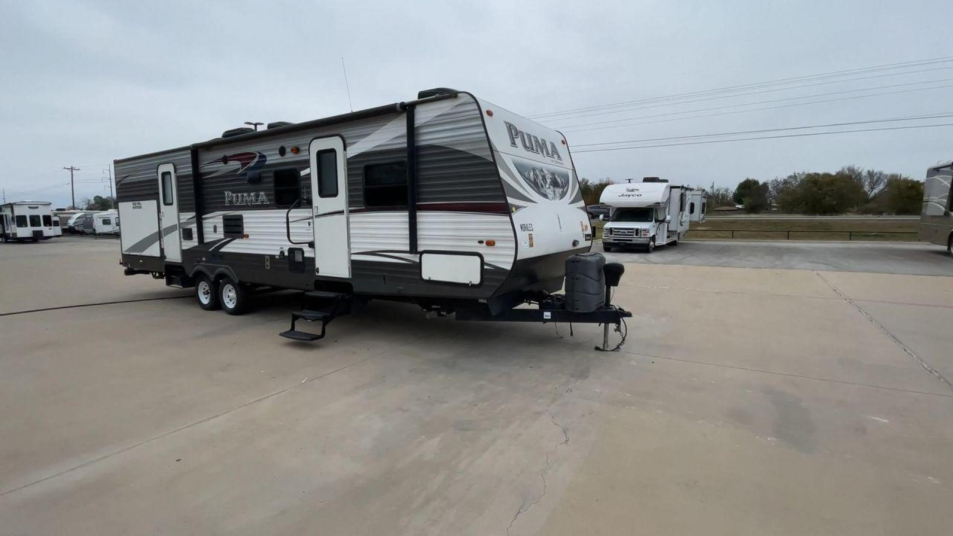 2015 FOREST RIVER PUMA 31BHSS (4X4TPUG21FP) , Length: 35.33 ft. | Dry Weight: 7,702 lbs. | Gross Weight: 10,236 lbs. | Slides: 2 transmission, located at 4319 N Main Street, Cleburne, TX, 76033, (817) 221-0660, 32.435829, -97.384178 - The 2015 Forest River Puma 31BH RV features a classic and durable exterior design. The body of the RV is a combination of gray, white, and black with accents of maroon, which gives it a rugged yet stylish look. The sides have aluminum panels with a ribbed texture, which not only adds to the aestheti - Photo#3