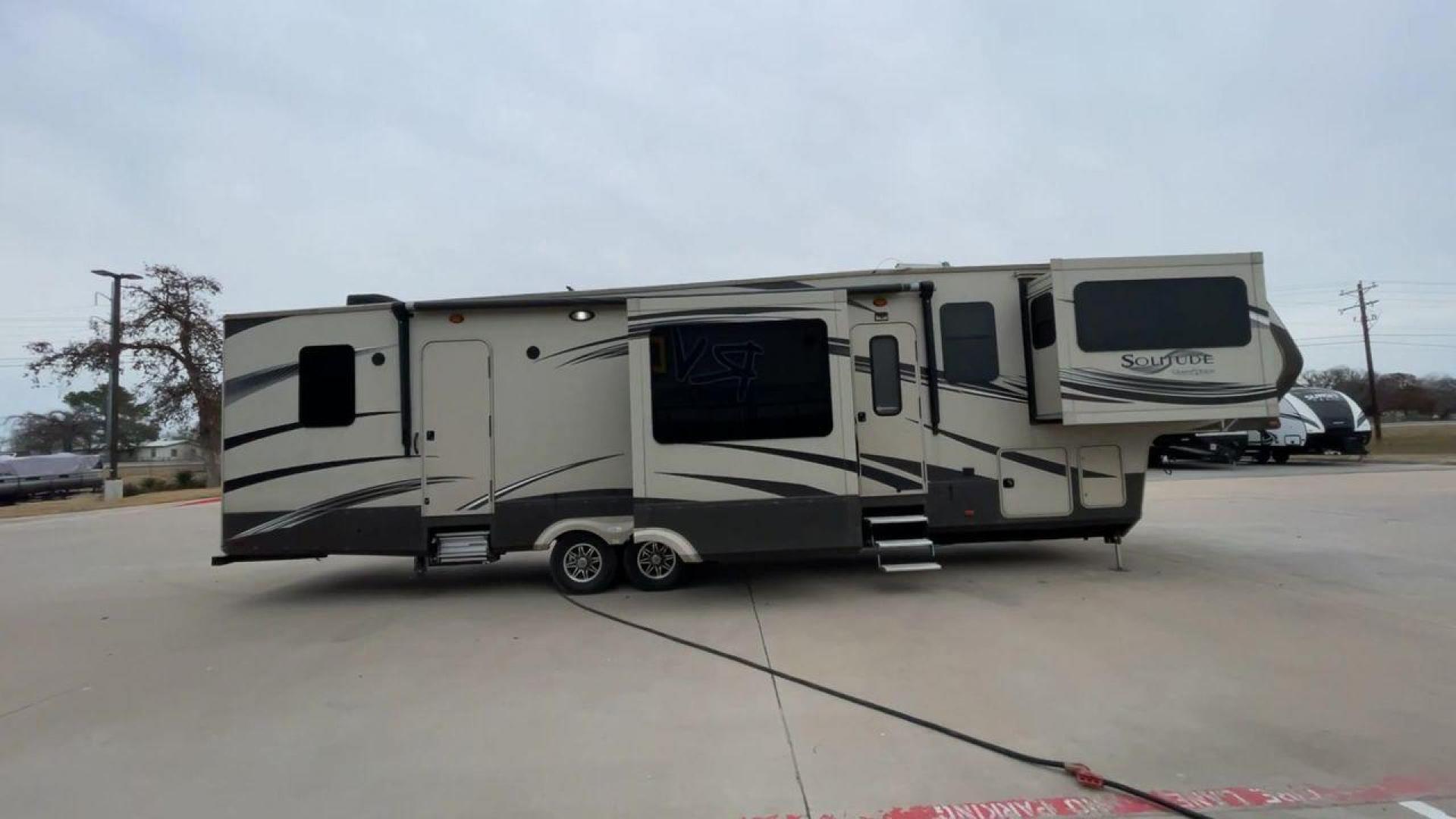 2015 BEIGE GRAND DESIGN SOLITUDE 379FL (573FS4325F1) , Length: 42.5 ft. | Dry Weight: 13,800 lbs. | Gross Weight: 16,000 lbs. | Slides: 5 transmission, located at 4319 N Main Street, Cleburne, TX, 76033, (817) 221-0660, 32.435829, -97.384178 - This 2015 GRSL Solitude 379 fifth wheel measures just over 42' in length. It is a dual axle and aluminum wheel setup with a GCWR of 16,000 lbs and a carrying capacity of 2,200 lbs. With five slides, this fifth wheel is spacious and comfortable! The Solitude's exterior is made from fiberglass, finish - Photo#2