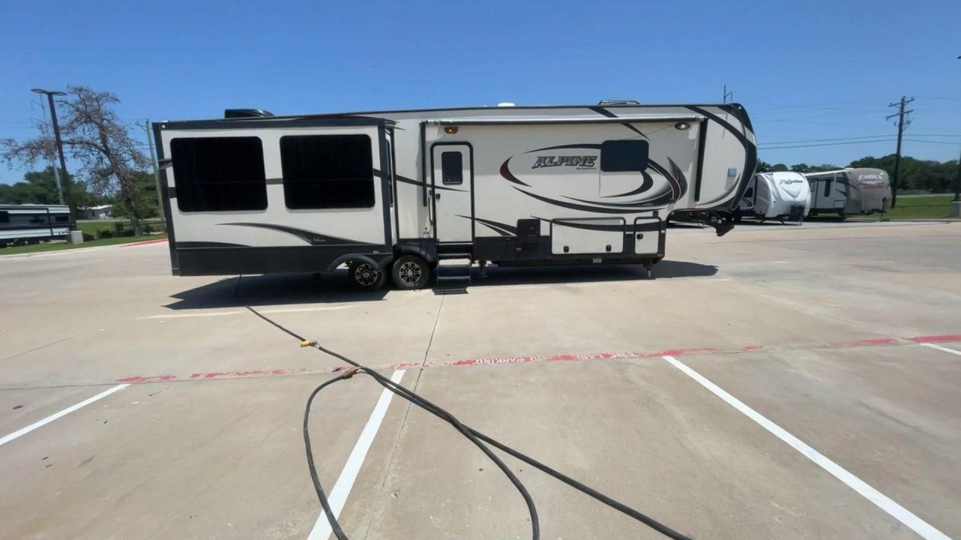 2015 WHITE KEYSTONE ALPINE 3535RE (4YDF35320FE) , Length: 39.08 ft. | Dry Weight: 12,416 lbs. | Gross Weight: 15,500 lbs. | Slides: 4 transmission, located at 4319 N Main Street, Cleburne, TX, 76033, (817) 221-0660, 32.435829, -97.384178 - Improve your RV experience with the 2015 Keystone Alpine 3535RE, a high-end fifth wheel that embodies ease and style. This model, which is an impressive 39.08 feet long, was carefully made for discerning travelers who want a perfect mix of style and usefulness. Because it is made of an aluminum body - Photo#2