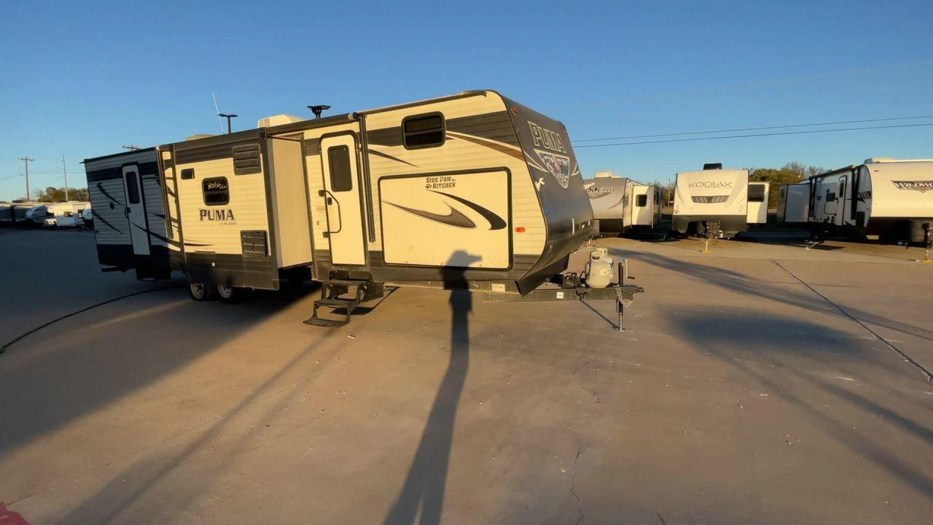 2016 TAN PUMA 32FBIS (4X4TPUH21GP) , Length: 35.33 ft. | Dry Weight: 8,858 lbs. | Gross Weight: 10,500 lbs. | Slides: 3 transmission, located at 4319 N Main Street, Cleburne, TX, 76033, (817) 221-0660, 32.435829, -97.384178 - The 2016 Puma 32FBIS travel trailer boasts a classic yet robust exterior that embodies convenience and practicality for family trips and long getaways. The travel trailer features aluminum siding in a silver tone, accentuated with subtle brown and black graphic designs that add a sleek, modern touch - Photo#3