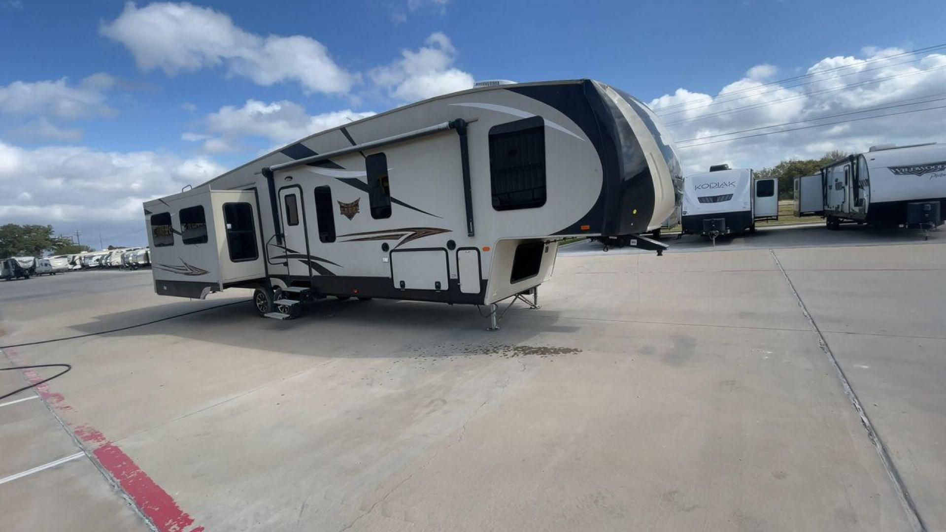 2016 TAN SABRE 365MB (4X4FSRN29G3) , Length: 42.42 ft. | Dry Weight: 12,994 lbs. | Gross Weight: 15,500 lbs. | Slides: 4 transmission, located at 4319 N Main Street, Cleburne, TX, 76033, (817) 221-0660, 32.435829, -97.384178 - The 2016 Sabre 365MB Fifth Wheel stretches 42.42 feet in length, with a commanding presence on the road and at the campground. The exterior is finished in a beige and black color scheme, accented with bold swooping graphics that add an athletic flair to its overall look. The side profile features fo - Photo#3