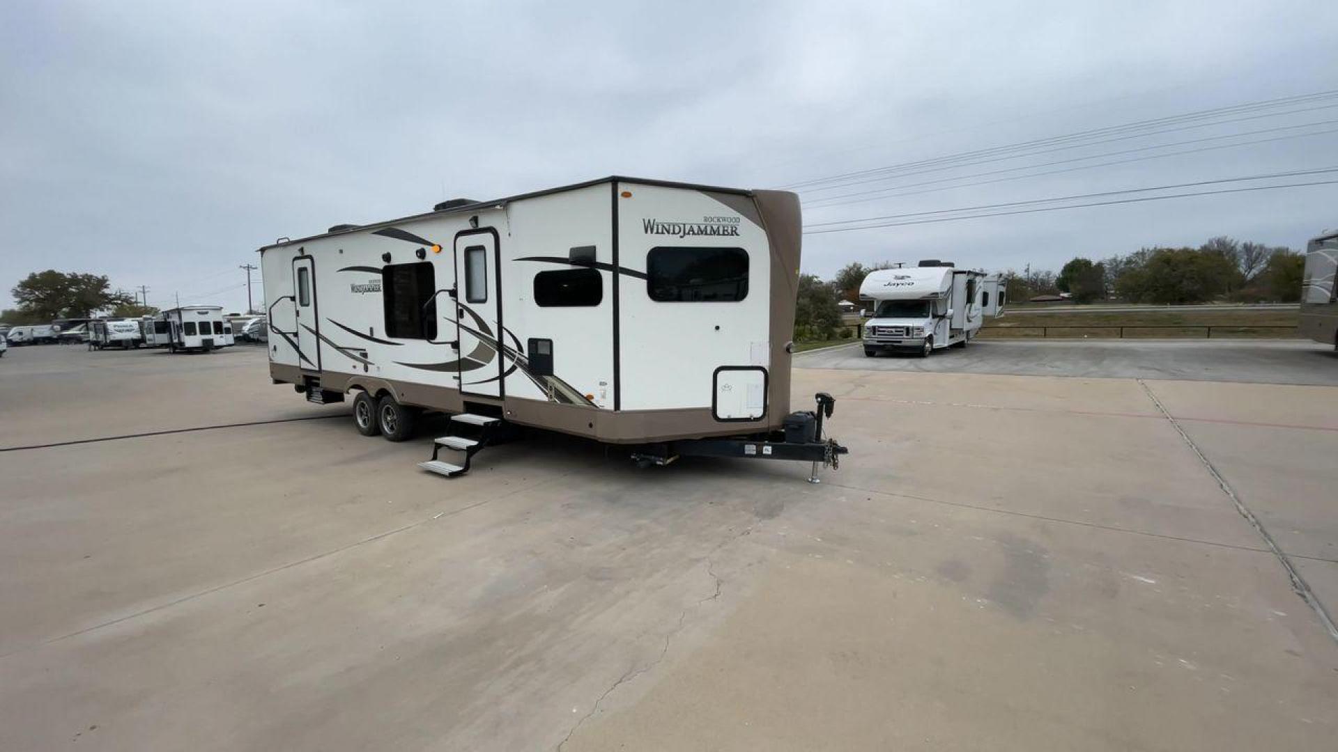 2019 FOREST RIVER WINDJAMMER 3008V (4X4TRLF24K1) , Length: 34 ft | Dry Weight: 7,433 lbs | Slides: 2 transmission, located at 4319 N Main Street, Cleburne, TX, 76033, (817) 221-0660, 32.435829, -97.384178 - Measuring 34 ft long, the 2019 Forest River Windjammer 3008V travel trailer is sleek and modern. The body features a white fiberglass surface accented with brown and black decals that provide a stylish and aerodynamic look. The front of the trailer is distinct with its pointed V-nose design. This en - Photo#3