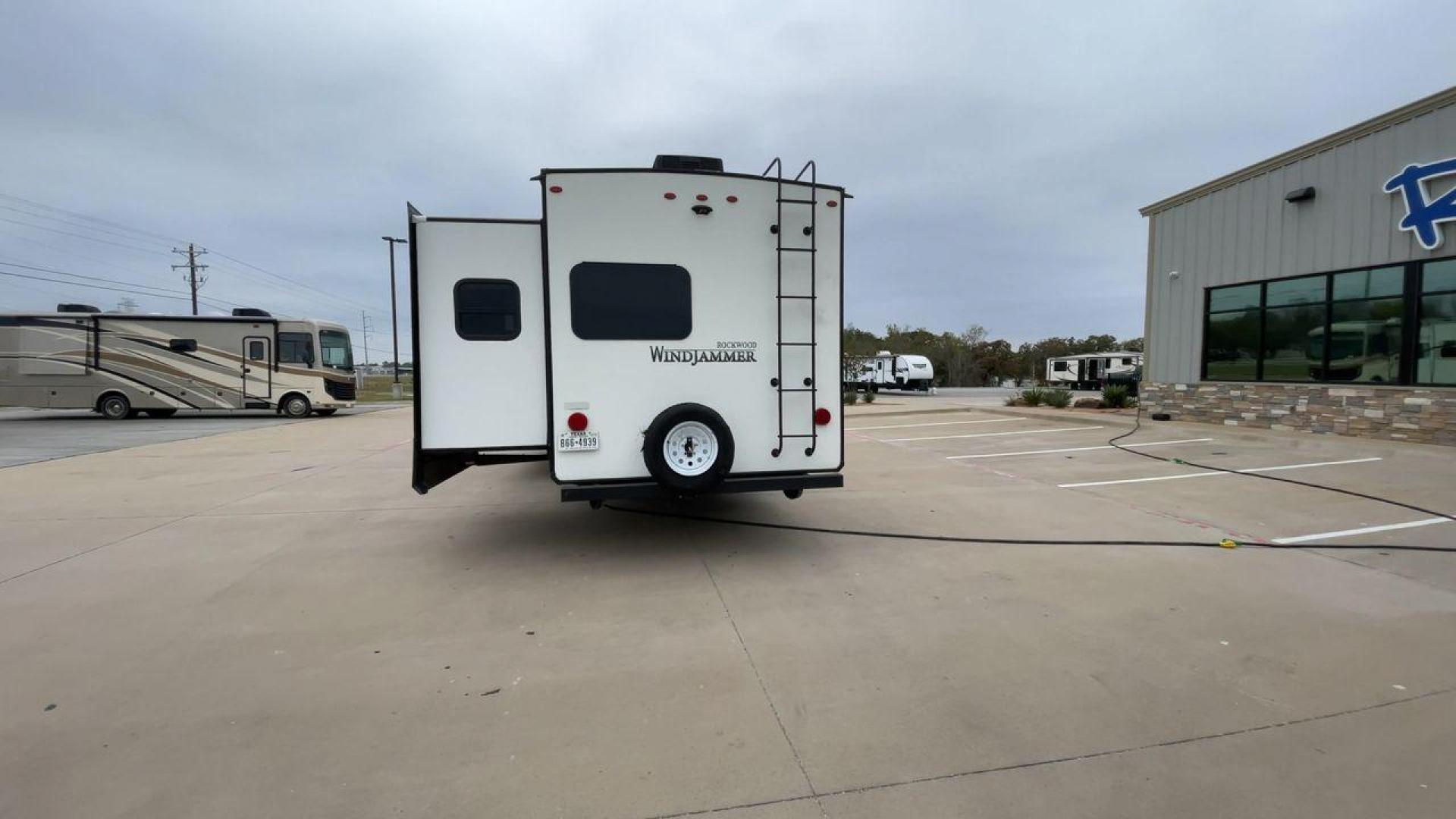 2019 FOREST RIVER WINDJAMMER 3008V (4X4TRLF24K1) , Length: 34 ft | Dry Weight: 7,433 lbs | Slides: 2 transmission, located at 4319 N Main Street, Cleburne, TX, 76033, (817) 221-0660, 32.435829, -97.384178 - Measuring 34 ft long, the 2019 Forest River Windjammer 3008V travel trailer is sleek and modern. The body features a white fiberglass surface accented with brown and black decals that provide a stylish and aerodynamic look. The front of the trailer is distinct with its pointed V-nose design. This en - Photo#8