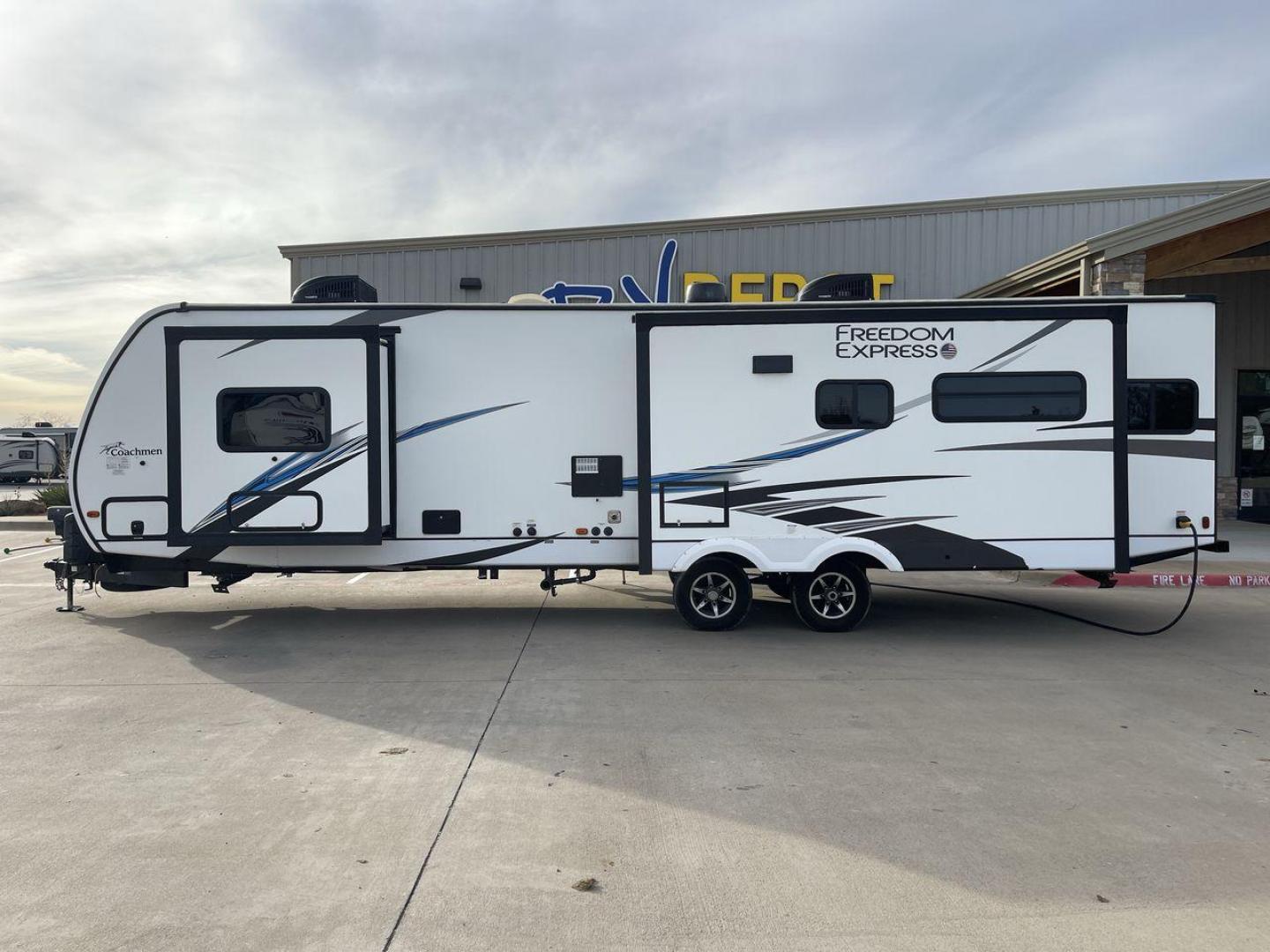 2020 FOREST RIVER FREEDOM EXPRESS (5ZT2FEXBXLW) , Length: 36.92 ft | Dry Weight: 8,328 lbs | Gross Weight: 10,500 lbs | Slides: 3 transmission, located at 4319 N Main Street, Cleburne, TX, 76033, (817) 221-0660, 32.435829, -97.384178 - The 2020 Freedom Express 324RLDS has a white body accented with sleek black and blue graphics, creating a stylish look. The front cap features an aerodynamic shape with bold design lines and a large tinted window. A sturdy electric tongue jack is positioned at the hitch for easy adjustments, complem - Photo#24