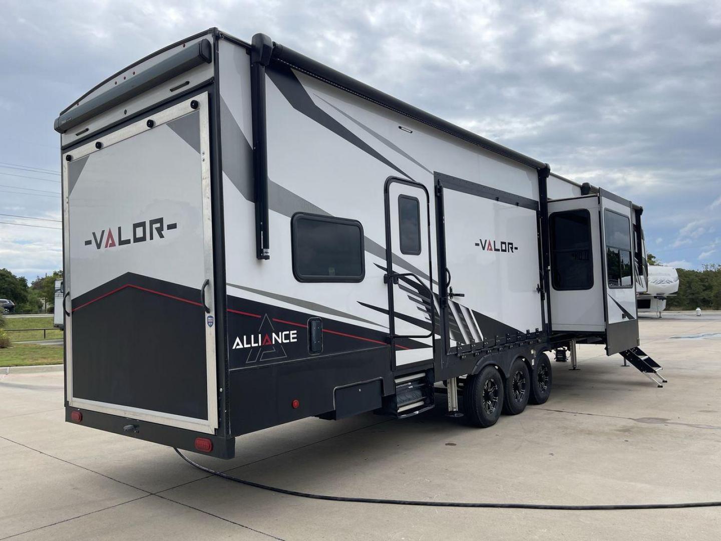 2021 ALLIANCE VALOR 42V13 (7M5FV4533MA) , Length: 44.08 ft. | Dry Weight: 16,064 lbs. | Gross Weight: 20,000 lbs. | Slides: 3 transmission, located at 4319 N Main Street, Cleburne, TX, 76033, (817) 221-0660, 32.435829, -97.384178 - The Valor 42V13 features a striking modern exterior with clean lines, highlighted by its sleek black, white, and gray color scheme. The multiple slide-outs (3) enhance interior space, while the large windows offer plenty of natural light. The rear garage entry has a ramp door for easy loading of rec - Photo#25