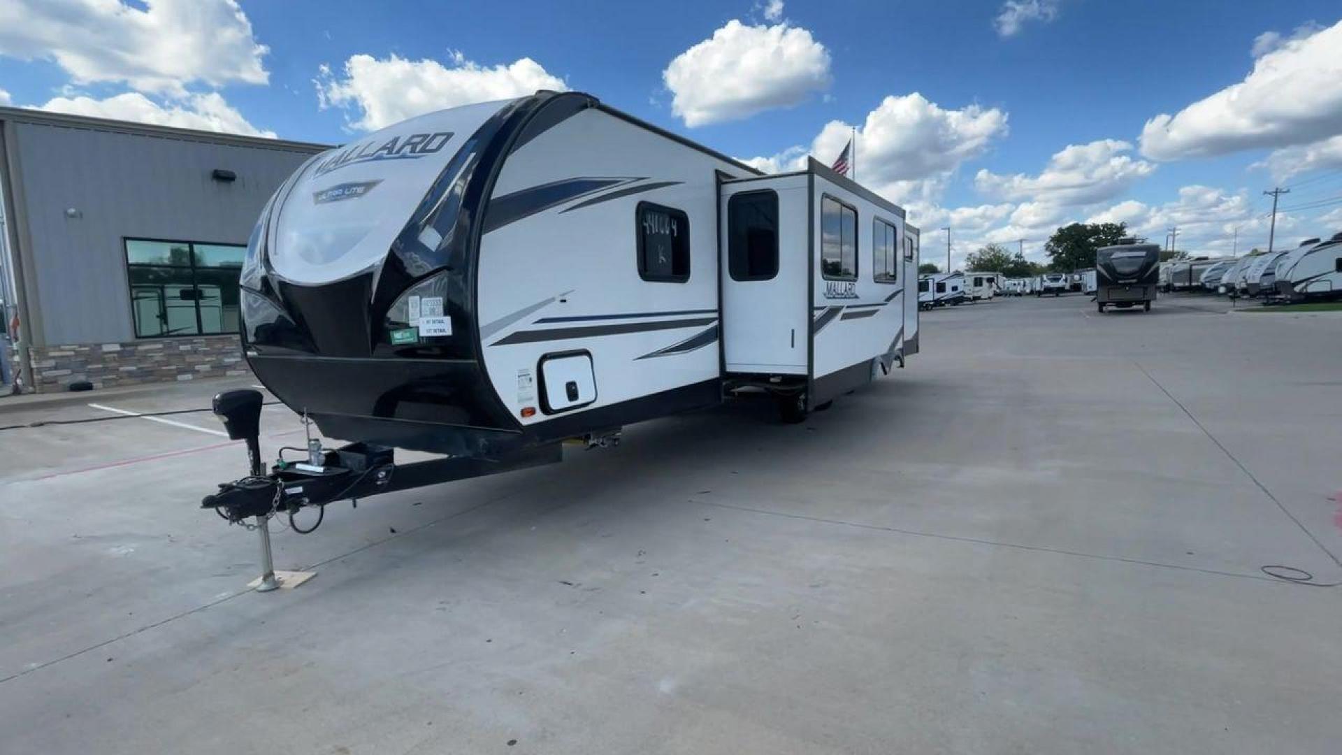 2021 HEARTLAND MALLARD M32 (5SFNB3524ME) , Length: 34.79 ft. | Dry Weight: 6,926 lbs. | Gross Weight: 8,600 lbs. | Slides: 2 transmission, located at 4319 N Main Street, Cleburne, TX, 76033, (817) 221-0660, 32.435829, -97.384178 - The 2021 Heartland Mallard M32 is a sleek and modern travel trailer with a length of 34.79 feet and a dry weight of 6,926 lbs. The gross weight is 8,600 lbs, making it easily towable by larger SUVs and trucks. It features a clean, white exterior with stylish blue and black decals that run along the - Photo#5