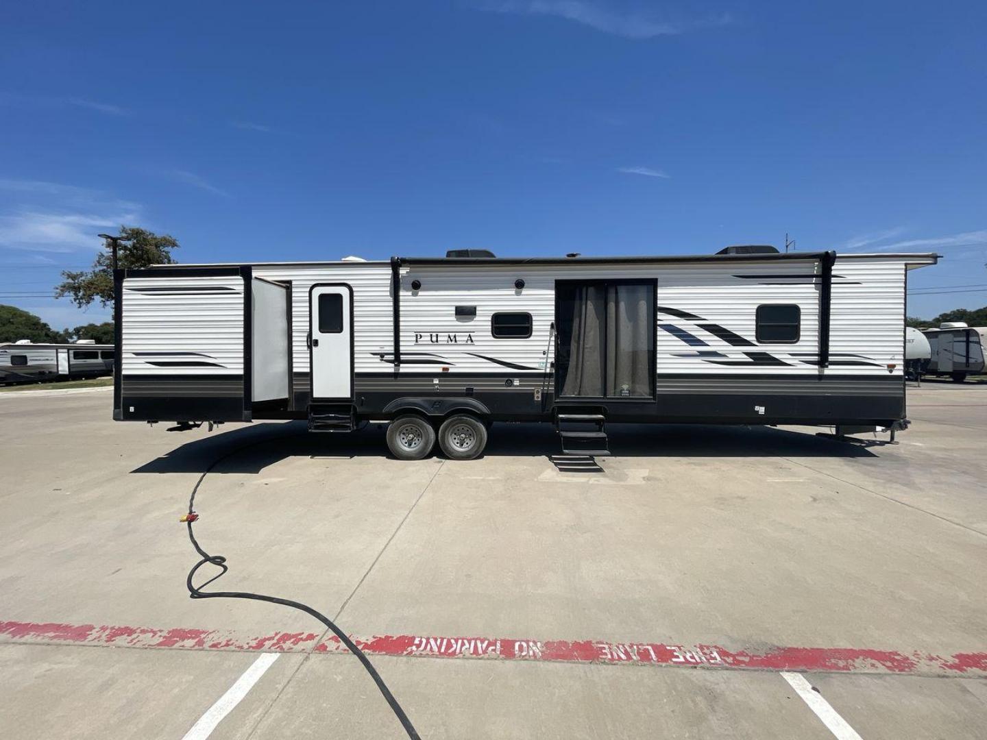 2021 TAN PUMA 39PQB - (4X4TPUR25MP) , located at 4319 N Main Street, Cleburne, TX, 76033, (817) 221-0660, 32.435829, -97.384178 - This Puma Travel Trailer measures just over 42 feet long and 8 feet wide with a dry weight of 10,709 lbs. It has a GVWR of 13,413 lbs and a hitch weight of 1,413 lbs. This unit comes with automatic heating and cooling rated at 35,000 and 13,500 BTUs respectively. The exterior of this unit is a base - Photo#24