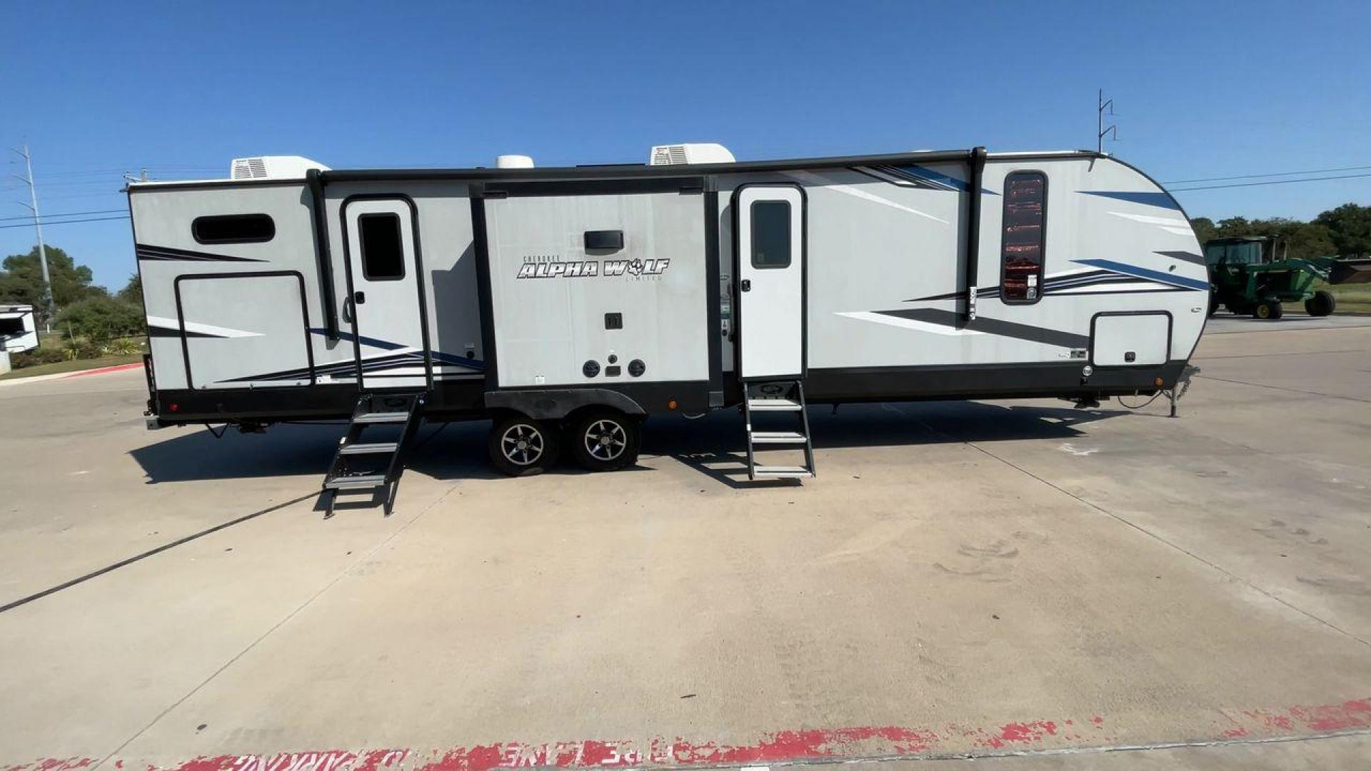 2022 FOREST RIVER CHEROKEE 33BH-L (5ZT2CKYBXN2) , Length: 37.33 ft. | Dry Weight: 7,986 lbs. | Gross Weight: 9,863 lbs. | Slides: 2 transmission, located at 4319 N Main Street, Cleburne, TX, 76033, (817) 221-0660, 32.435829, -97.384178 - The 2022 Forest River Cherokee Alpha Wolf 33BH-L showcases a modern and sleek exterior which is perfectly built for extended road adventures. Measuring 37.33 feet in length, it features a two-tone gray and black color scheme with sharp, angular graphics that give it a contemporary, aggressive look. - Photo#2