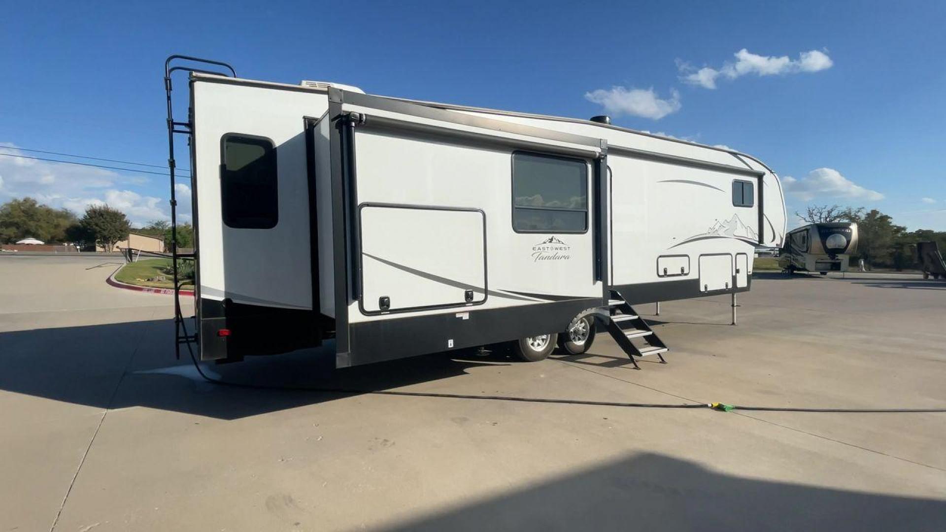 2022 FOREST RIVER EAST TO WEST TANDARA (5ZT3TD4B6N9) , Length: 41.25 ft | Dry Weight: 13,179 lbs | Slides: 4 transmission, located at 4319 N Main Street, Cleburne, TX, 76033, (817) 221-0660, 32.435829, -97.384178 - At 41.25 ft. long, the front cap showcases a bold "East to West Tandara" logo, accentuated by clean, aerodynamic curves. Large, tinted windows provide natural light while maintaining privacy. Four (4) slideouts expand the living space, enhancing functionality when parked. The trailer is equipped wit - Photo#1