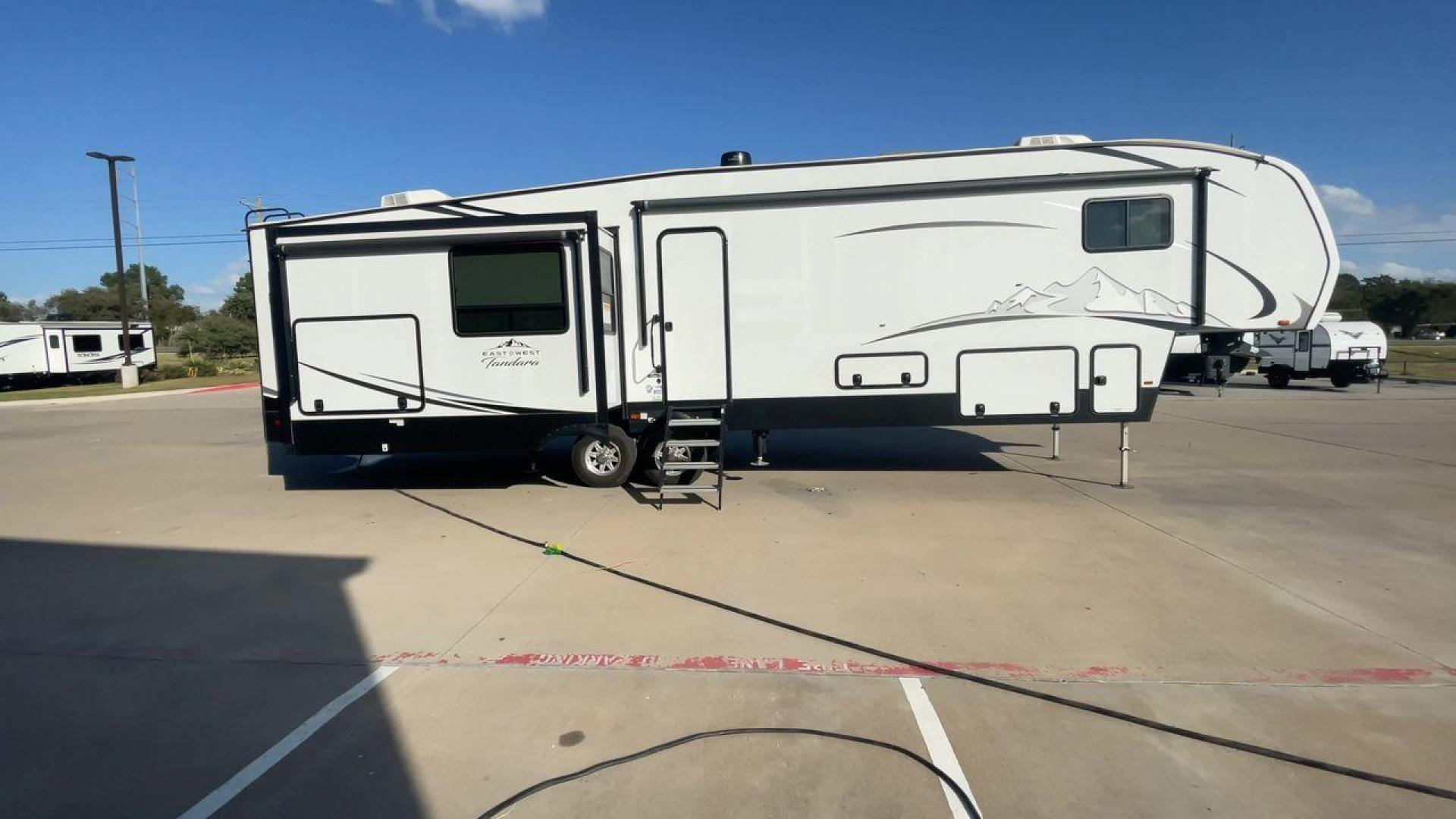 2022 FOREST RIVER EAST TO WEST TANDARA (5ZT3TD4B6N9) , Length: 41.25 ft | Dry Weight: 13,179 lbs | Slides: 4 transmission, located at 4319 N Main Street, Cleburne, TX, 76033, (817) 221-0660, 32.435829, -97.384178 - At 41.25 ft. long, the front cap showcases a bold "East to West Tandara" logo, accentuated by clean, aerodynamic curves. Large, tinted windows provide natural light while maintaining privacy. Four (4) slideouts expand the living space, enhancing functionality when parked. The trailer is equipped wit - Photo#2