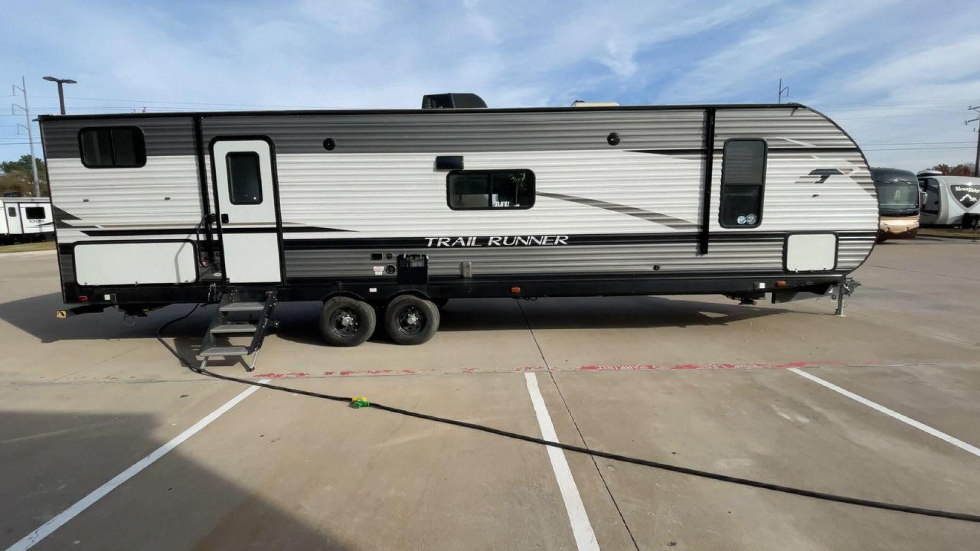 2022 HEARTLAND TRAIL RUNNER 31DB (5SFEB372XNE) , Length: 36.92 ft. | Dry Weight: 7,040 lbs. | Gross Weight: 9,642 lbs. | Slides: 1 transmission, located at 4319 N Main Street, Cleburne, TX, 76033, (817) 221-0660, 32.435829, -97.384178 - The 2022 Heartland Trail Runner 31DB has a robust and functional exterior design with modern accents. The front cap of the RV is curved for better aerodynamics, with the bold Trail Runner logo prominently displayed. The front also features a black diamond-plate guard, which offers protection from de - Photo#2