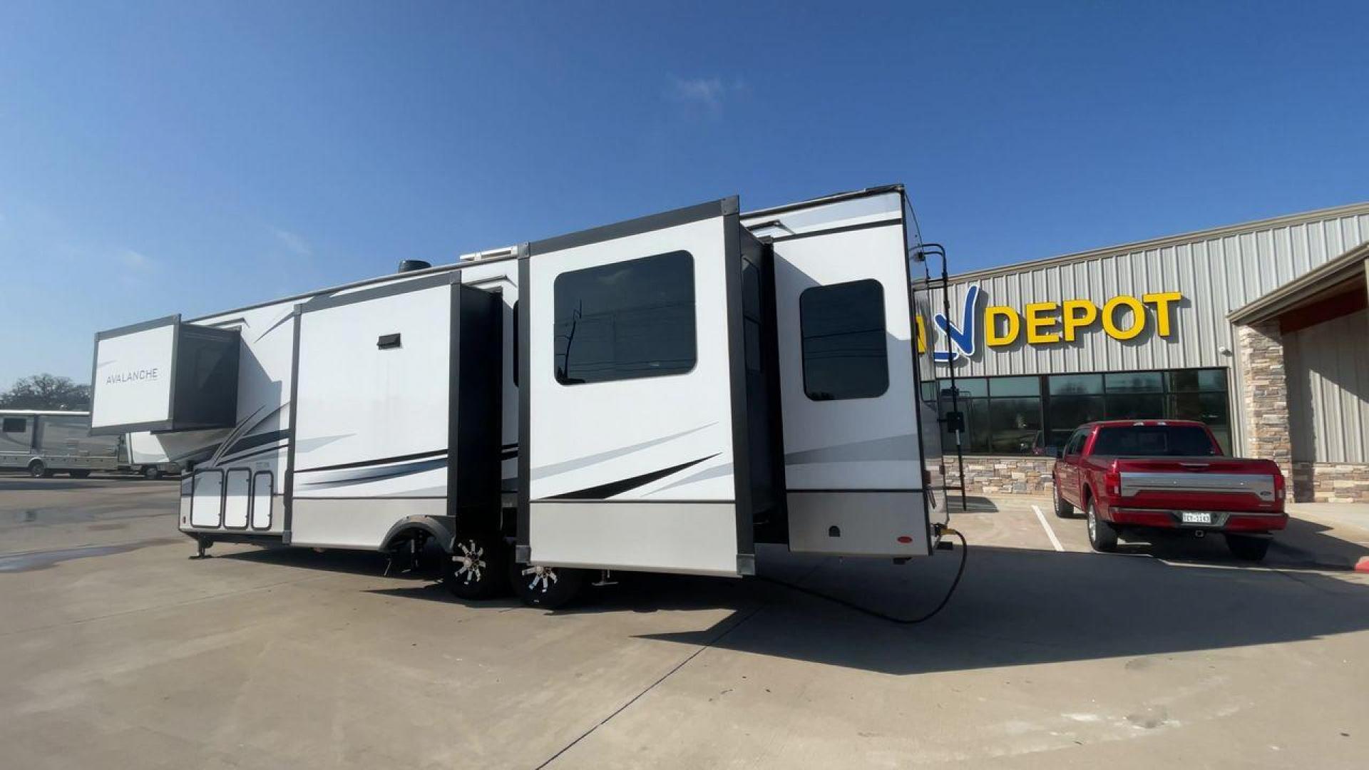 2022 KEYSTONE AVALANCHE 338GK (4YDFAVS24NE) , Length: 38 ft | Dry Weight: 12,523 lbs | Gross Weight: 15,500 lbs | Slides: 4 transmission, located at 4319 N Main Street, Cleburne, TX, 76033, (817) 221-0660, 32.435829, -97.384178 - The 2022 Keystone Avalanche 338GK showcases a sleek and modern exterior design, built for durability and style. This fifth wheel features a glossy white body accented by sharp, aerodynamic lines in subtle shades of gray and black, giving it a clean and contemporary look. The front cap is bold and ae - Photo#7